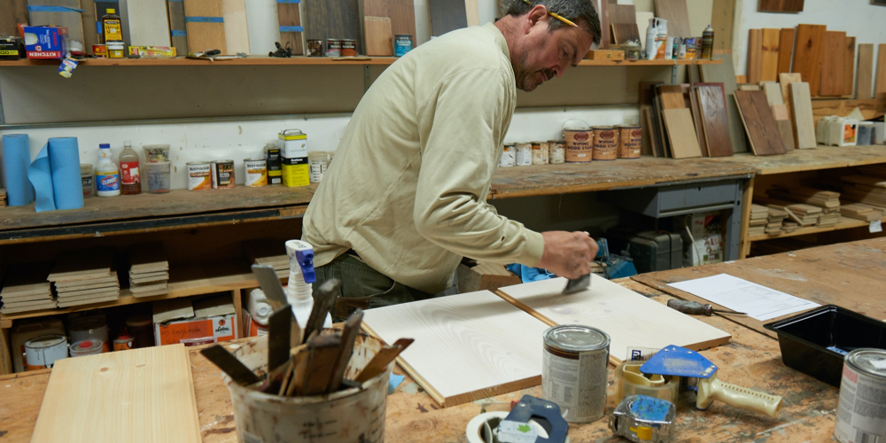 Man Applies Finish in Custom Hardwood Sample Shop